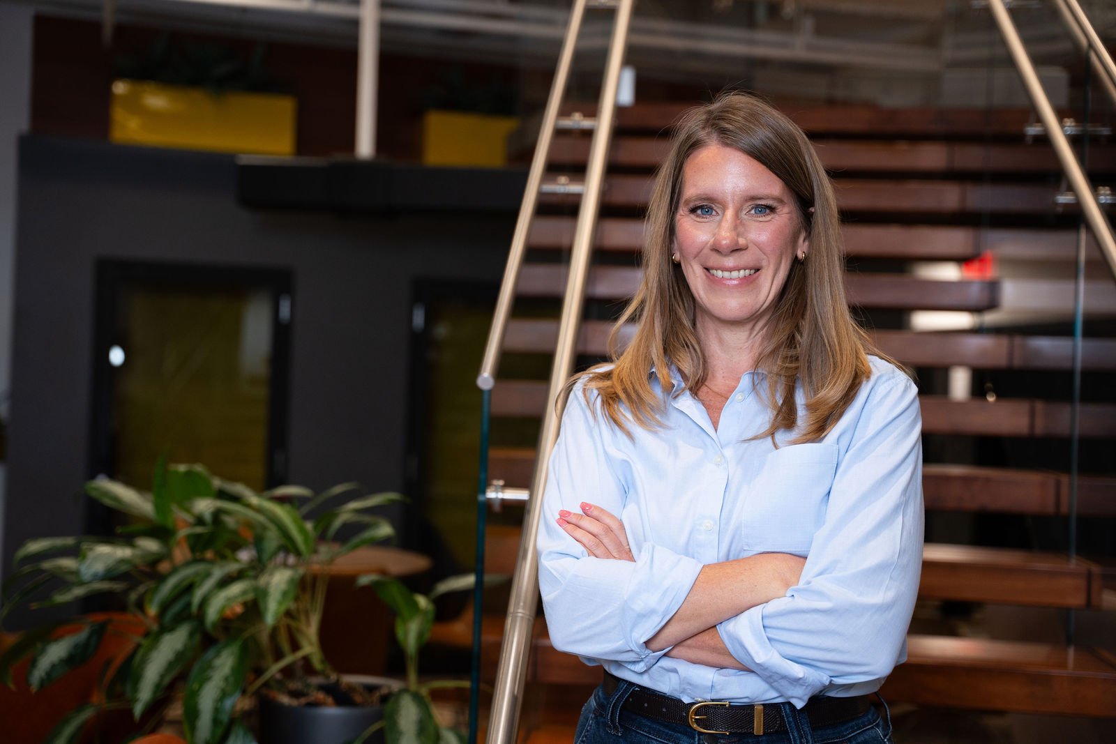 A smiling woman poses in a modern office