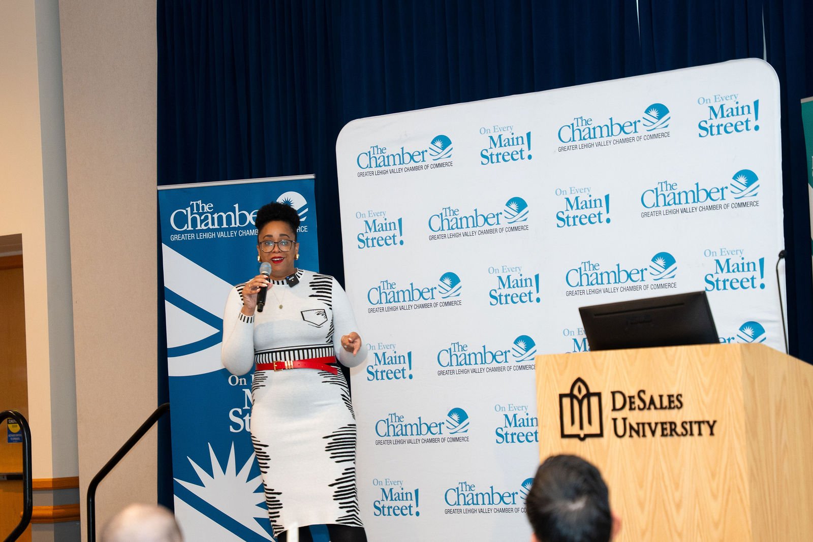 A speaker presents at a conference lectern