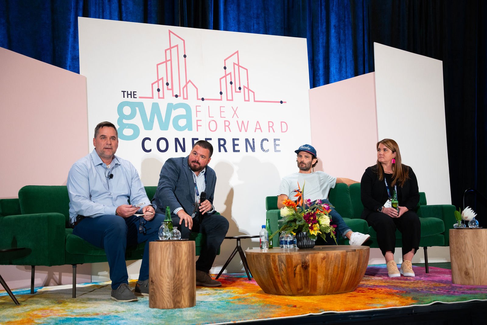 Four panelists sit on stage at a conference