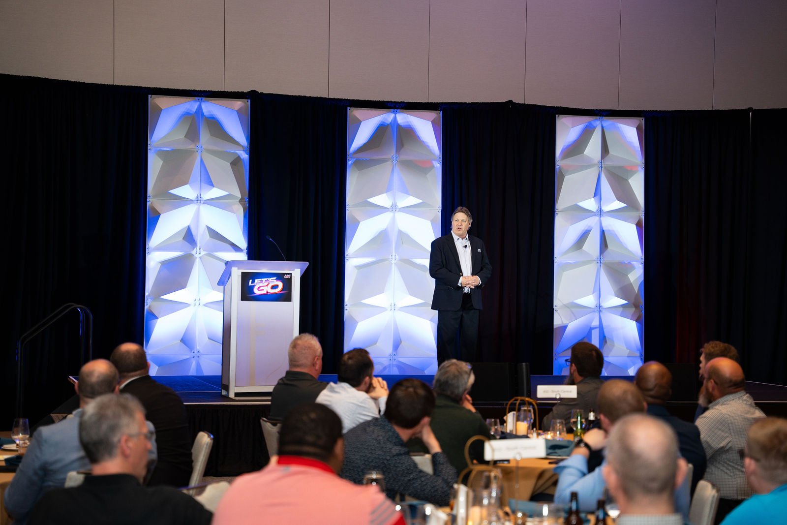 A presenter addresses an audience at an event