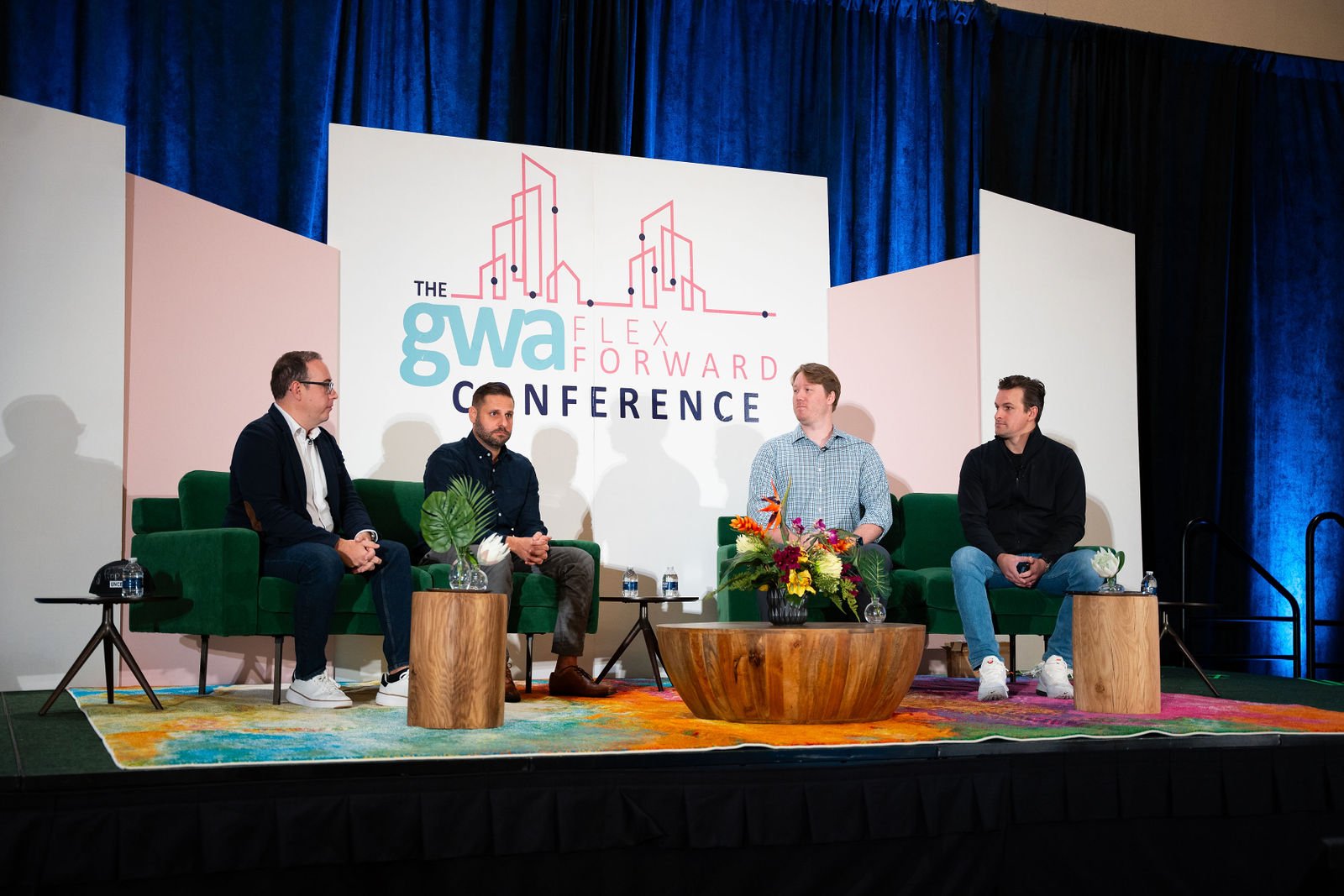 A panel discusses real estate on a conference stage