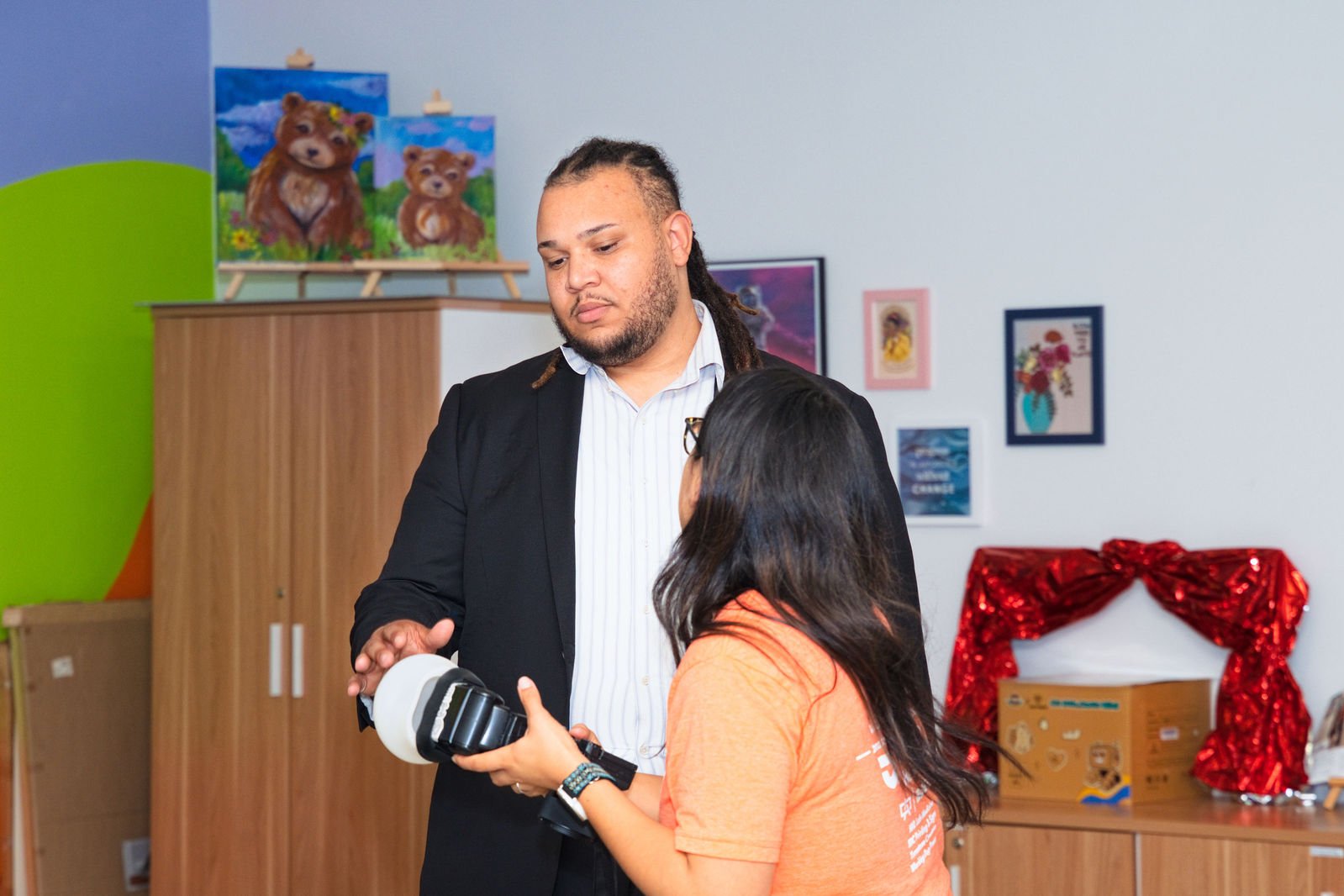 An instructor demonstrates a camera to a student
