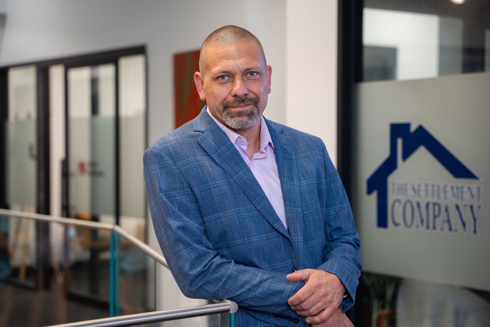 A man in a blue blazer poses at his office