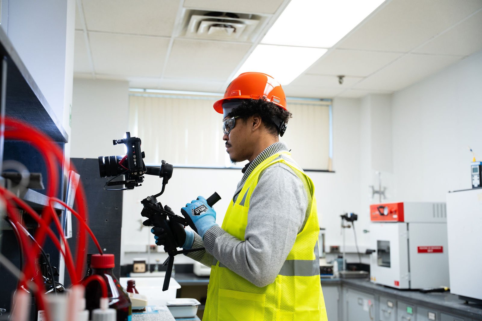 A camera operator films a production in a workshop