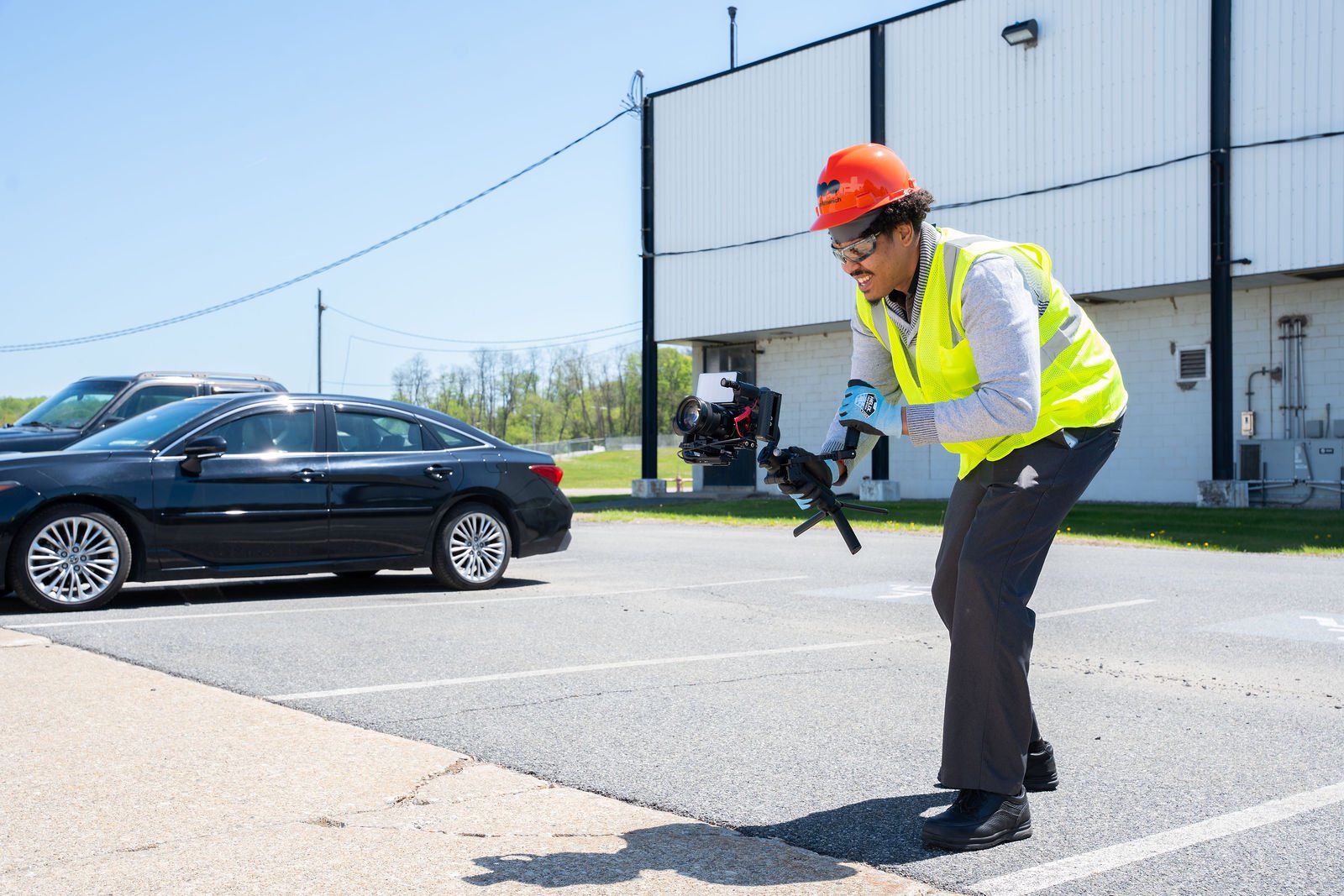 A photographer works outside in a safety vest