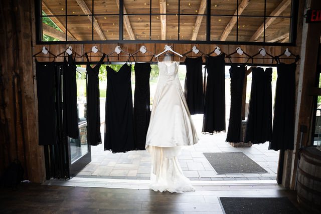 Kelly’s wedding dress hanging in a barn doorway