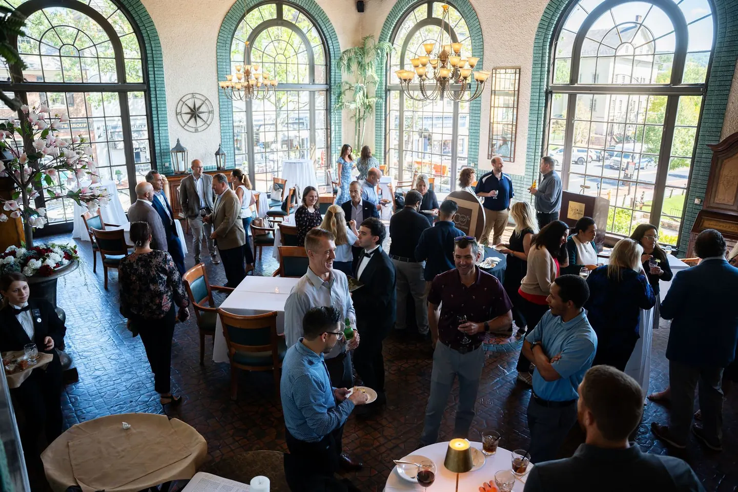 Guests mingle at a business gathering in a bright venue