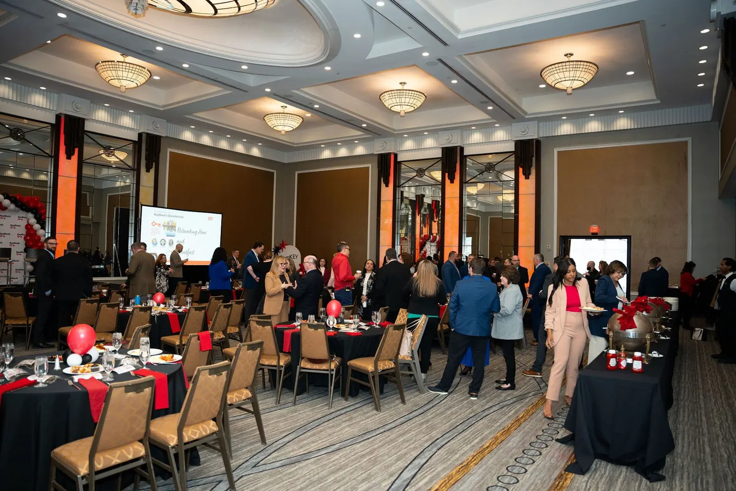 Guests sit at tables in a ballroom during a business event