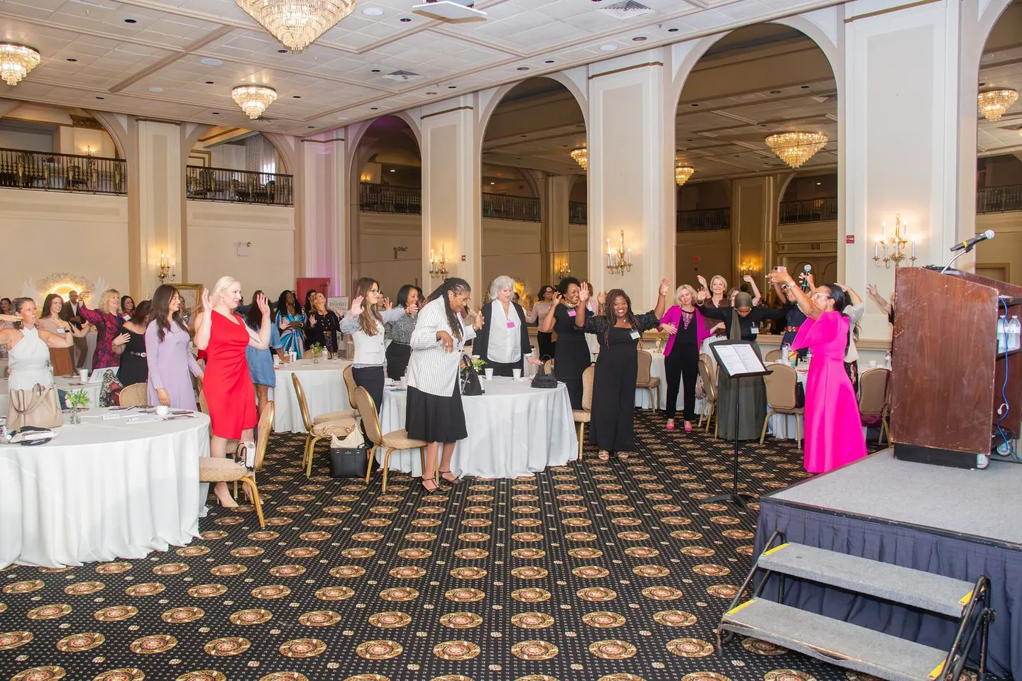 Guests gather beside a stage in a ballroom